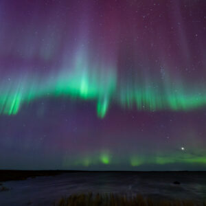 Vibrant Aurora Borealis over lake in Southwest Alaska