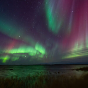 Vibrant Aurora Borealis over lake in Southwest Alaska