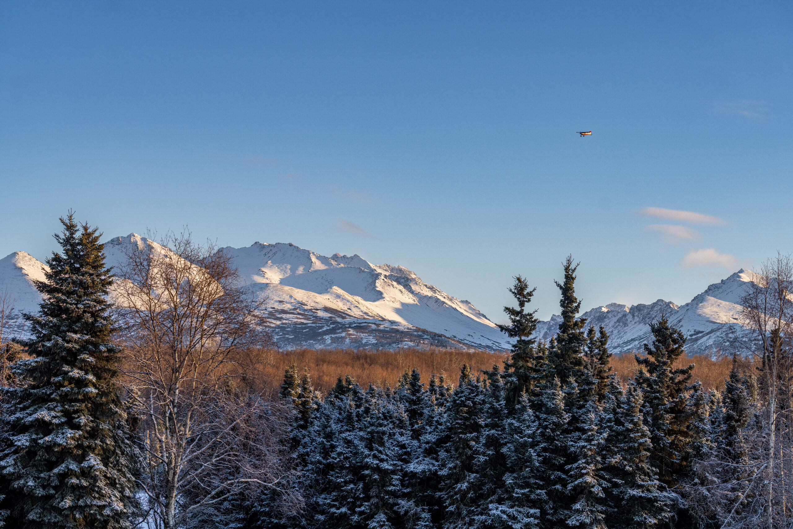 Plane flying low over the Chugach Mountain Range outside of Anchorage, Alaska