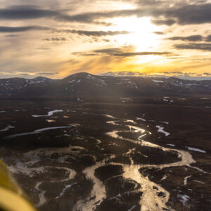 Vertical view of a vibrant sunset from the window of a small bush plane in Southwest Alaska